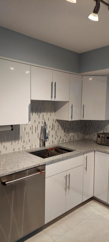 Kitchen remodeling project featuring professionally refinished white cabinets